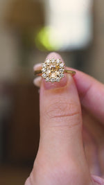 Antique inspired primrose-yellow sapphire and diamond cluster engagement ring highlighting the oval yellow sapphire and yellow gold gallery in video.