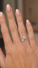 A video of an outstretched hand wearing an antique Edwardian era diamond  double cluster engagement ring in yellow gold and turned to show off the proportions