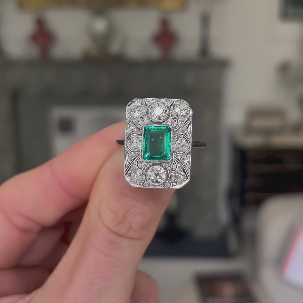 Art Deco emerald and diamond panel ring, held in fingers and rotated to give perspective