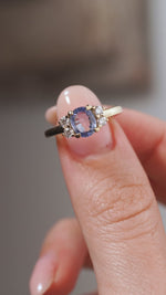 A close-up video of the vintage-inspired blue sapphire and diamond ring held between fingers, capturing the gemstone's soft blue facets and sparkling diamond accents.
