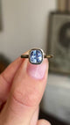 Close up video of an Antique-inspired, light purple coloured cushion-cut sapphire solitaire engagement ring in yellow gold, held between two fingers and rotated slowly to display all the profiles of the ring. 