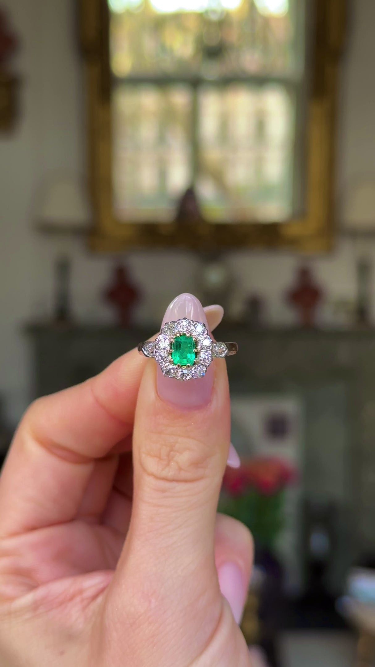 Edwardian emerald and diamond ring held in fingers and moved around to give perspective.
