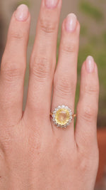 a video of Vintage, 1950s yellow sapphire and diamond cluster engagement ring worn on the hand
