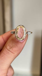 Closeup video of a Vintage, 1980s engagement ring with a large central yellow sapphire flanked by two diamonds on either side.  Rotated to showcase it from every profile. 