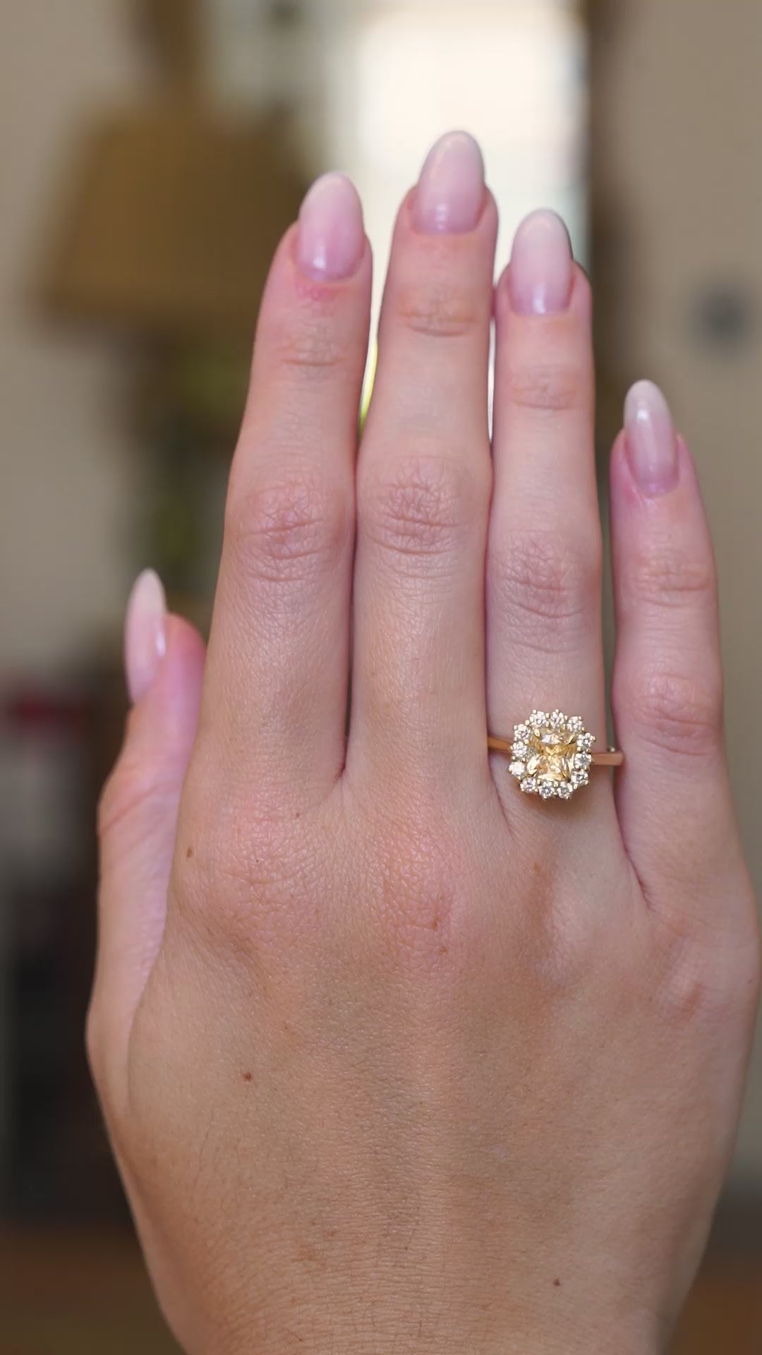 Antique inspired primrose-yellow sapphire and diamond cluster engagement ring worn on the hand showing subtle motion in video.