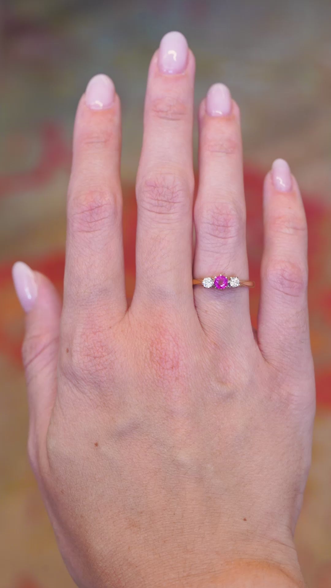 Vintage 1960s ruby and diamond three-stone ring worn on hand in motion.