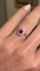 Close up video of a hand wearing a Vintage, 1940s ruby and diamond cluster engagement ring in yellow gold