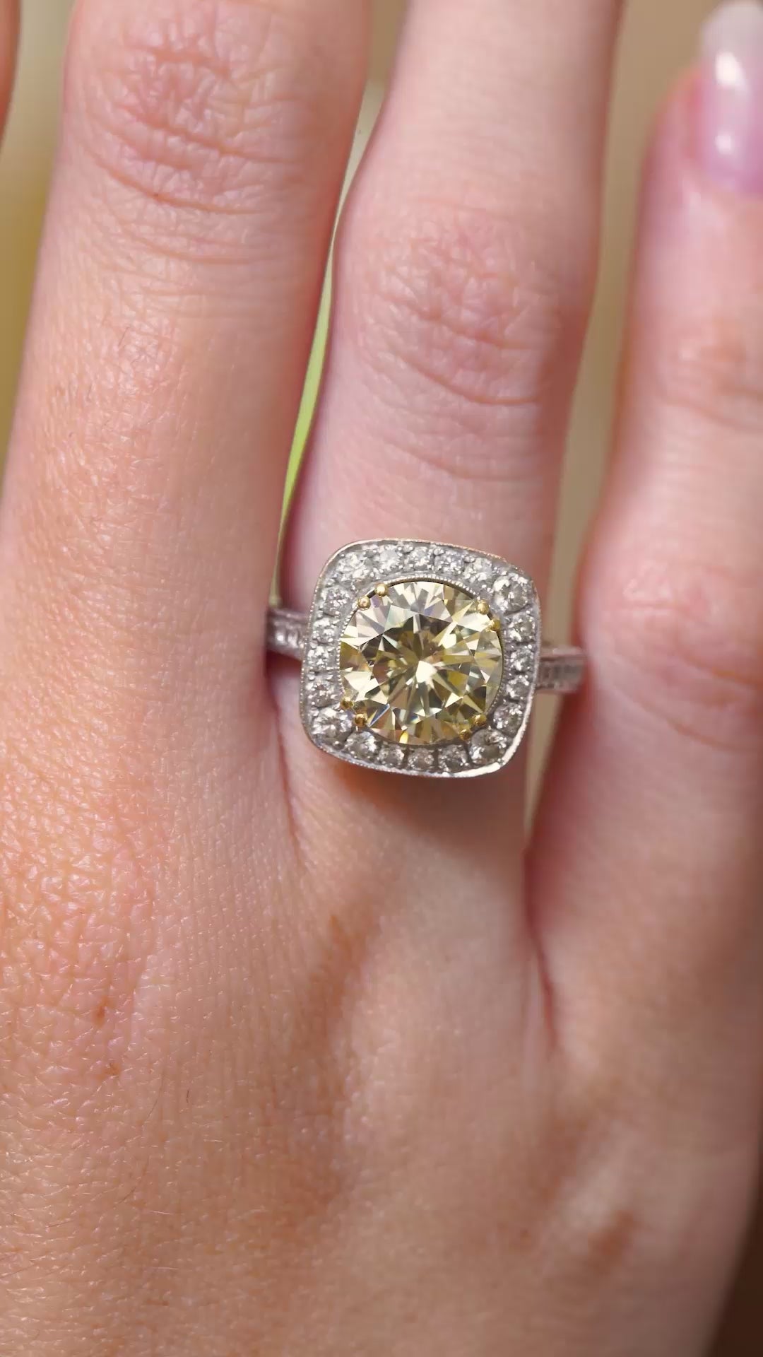 a video of Vintage, 1990s yellow tinted diamond cluster engagement ring being worn on the hand