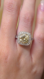 a video of Vintage, 1990s yellow tinted diamond cluster engagement ring being worn on the hand