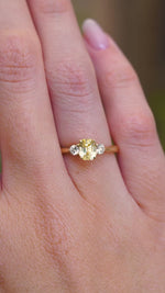 A video of a vintage-inspired yellow sapphire and diamond three-stone ring in yellow gold worn on a hand.
