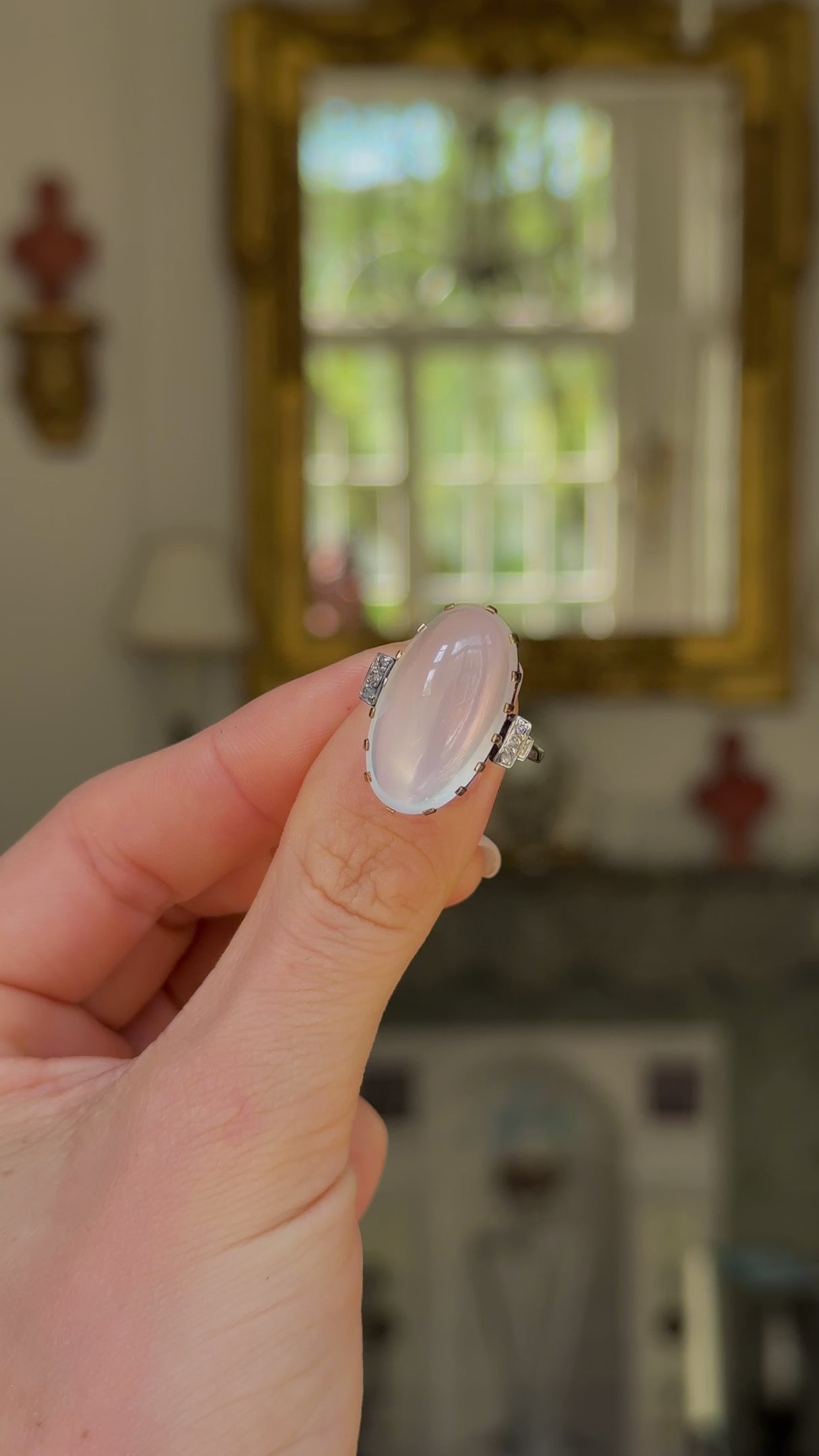 Moonstone and diamond ring, held in fingers and moved around to give perspective.