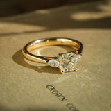 Princess cut 1.01ct yellow diamond with white diamond three stone engagement ring in yellow gold