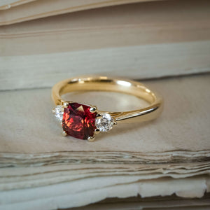 Red spinel and diamond three stone ring set in yellow gold