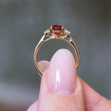 Red spinel and diamond three-stone engagement ring showing raised gold setting and under gallery.