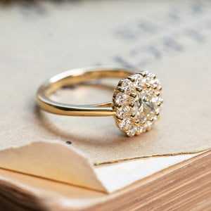 Diamond cluster engagement ring with brilliant-cut diamonds and yellow gold band.