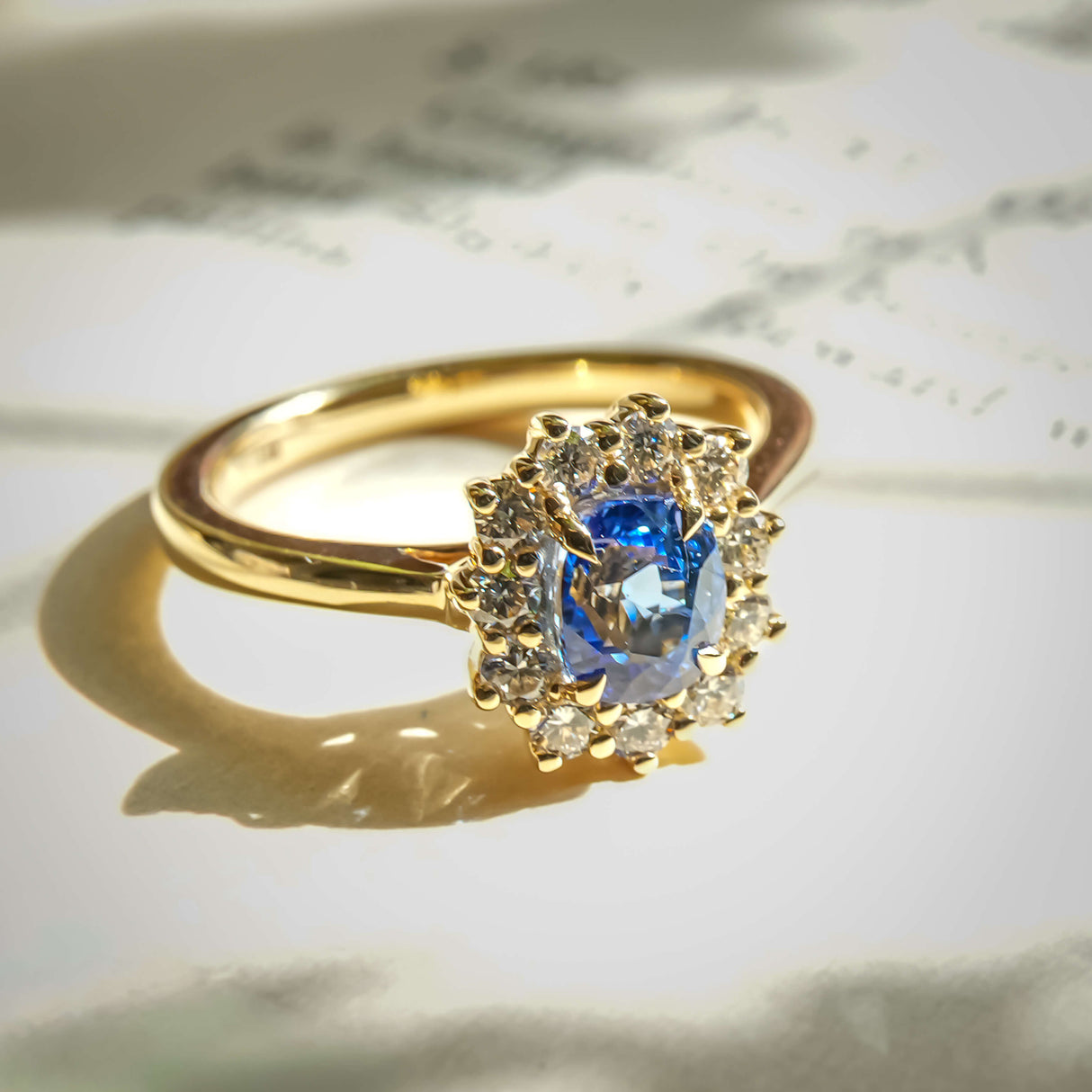 Royal blue sapphire and diamond cluster engagement ring in yellow gold band