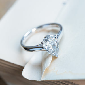 Vintage salt and pepper diamond solitaire ring with pear-shaped diamond in classic claw setting.