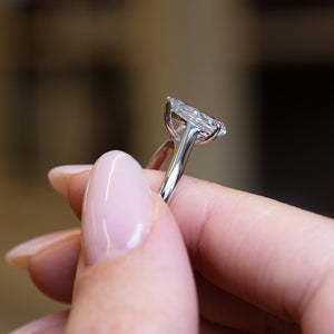 Vintage 1990s salt and pepper diamond solitaire ring held in hand showing open gallery beneath pear-shaped diamond.