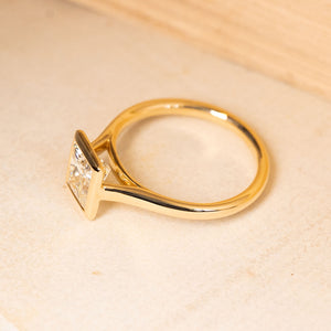 Princess-cut diamond solitaire ring showcasing a bright square diamond in an elegant yellow gold design.