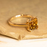 Step-cut golden chrysoberyl solitaire ring set in yellow gold with clean lines and elegant proportions.