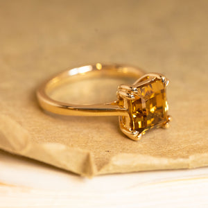 Step-cut golden chrysoberyl solitaire ring set in yellow gold with clean lines and elegant proportions.