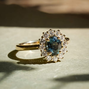 Teal sapphire and diamond cluster engagement ring in yellow gold