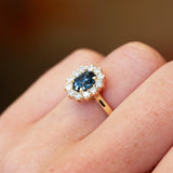 Sapphire and diamond cluster ring highlighting central stone and surrounding diamonds.