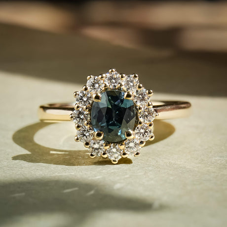 Teal sapphire center stone with diamond cluster halo engagement ring