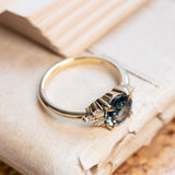 Teal sapphire and diamond cluster tre-foil engagement ring with sculpted gallery and diamond accents.