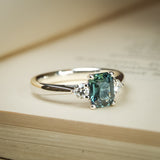 Teal sapphire and diamond three stone engagement ring with platinum setting