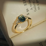 Teal sapphire ring with emerald cut gemstone and diamond trefoil cluster design