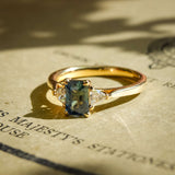 Teal sapphire center stone with trillion diamonds three stone engagement ring