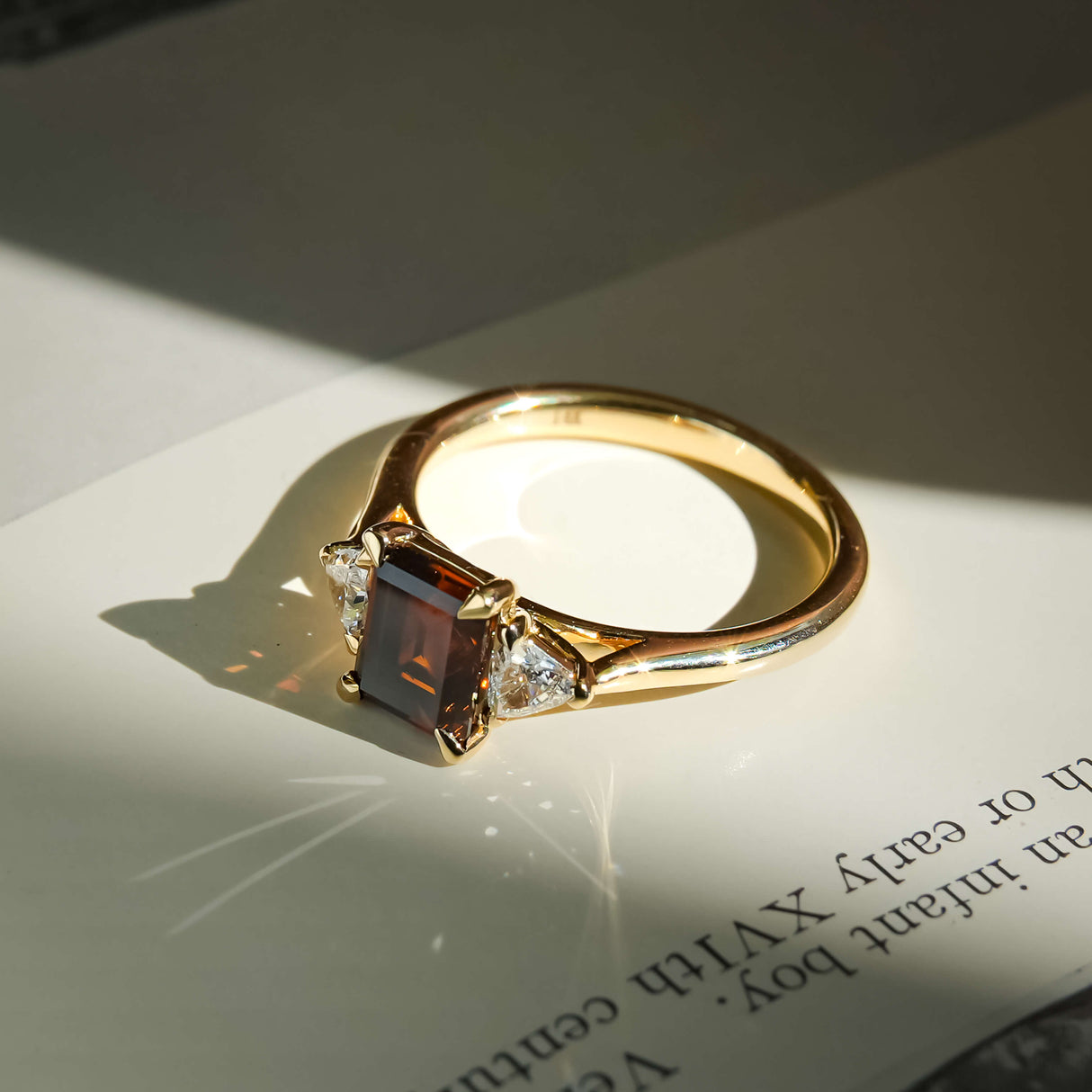 three stone brown diamond engagement ring with white diamond side stones in yellow gold