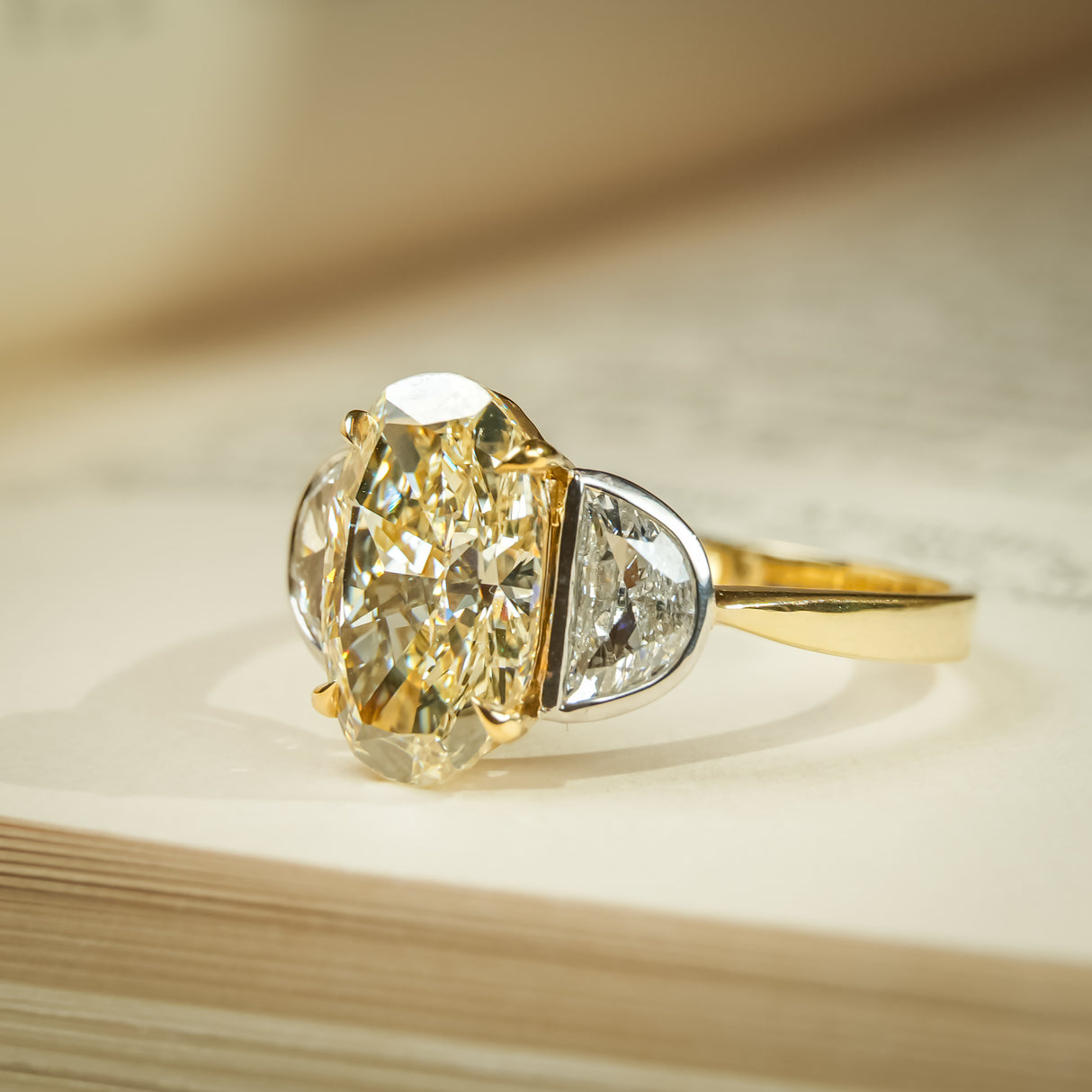 Three stone engagement ring with yellow oval diamond and half moon diamonds