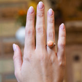 Victorian angel skin coral and diamond cluster ring worn on hand with soft pink manicure.