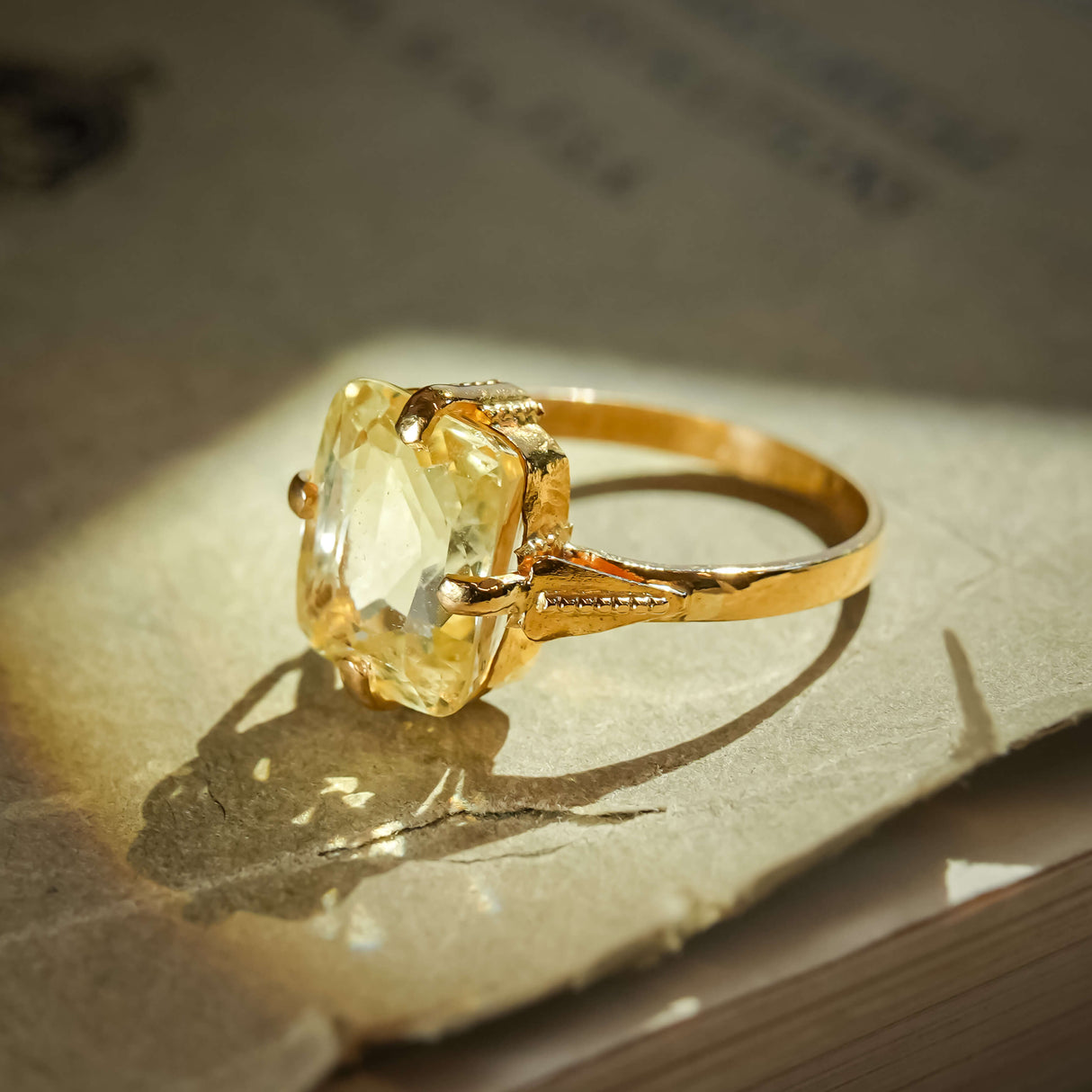 Victorian yellow sapphire solitaire ring shown from side angle with gold band