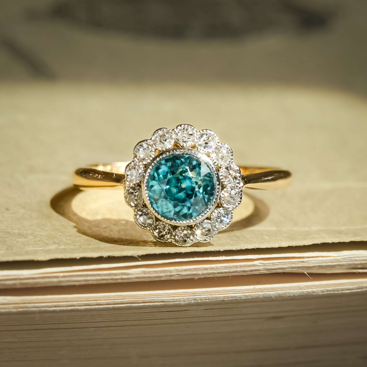 Vintage 1920s zircon ring with round blue zircon and diamond cluster halo