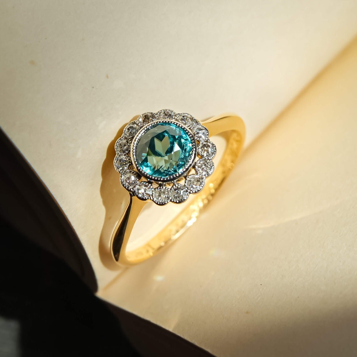 Vintage 1920s zircon and diamond cluster ring with round blue zircon in gold