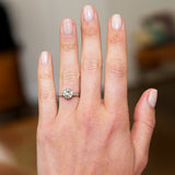 Hand wearing a tinted yellow diamond ring with a blurred background.