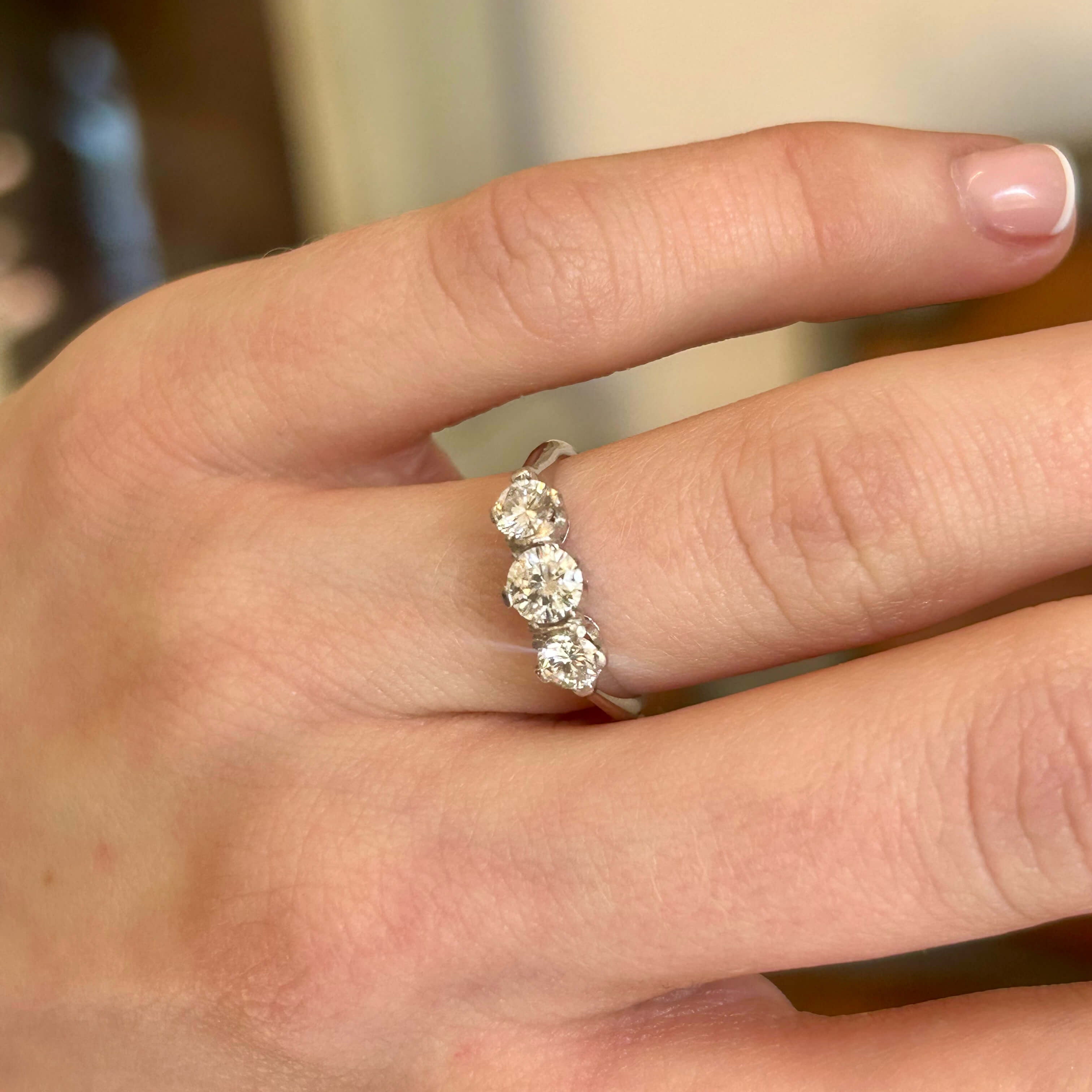 Vintage 1950s 18ct white gold diamond three stone ring worn on the hand.
