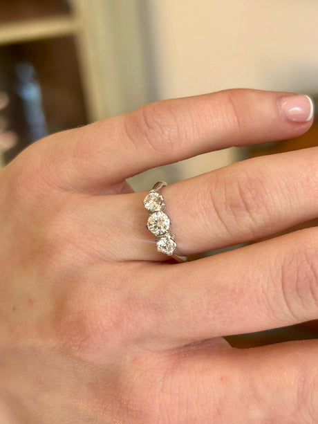 Vintage 1950s 18ct white gold diamond three stone ring worn on the hand.