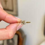 Vintage 1950s brown old-mine cut diamond solitaire engagement ring featuring a brown old-mine cut diamond in a classic solitaire setting, held by hand.