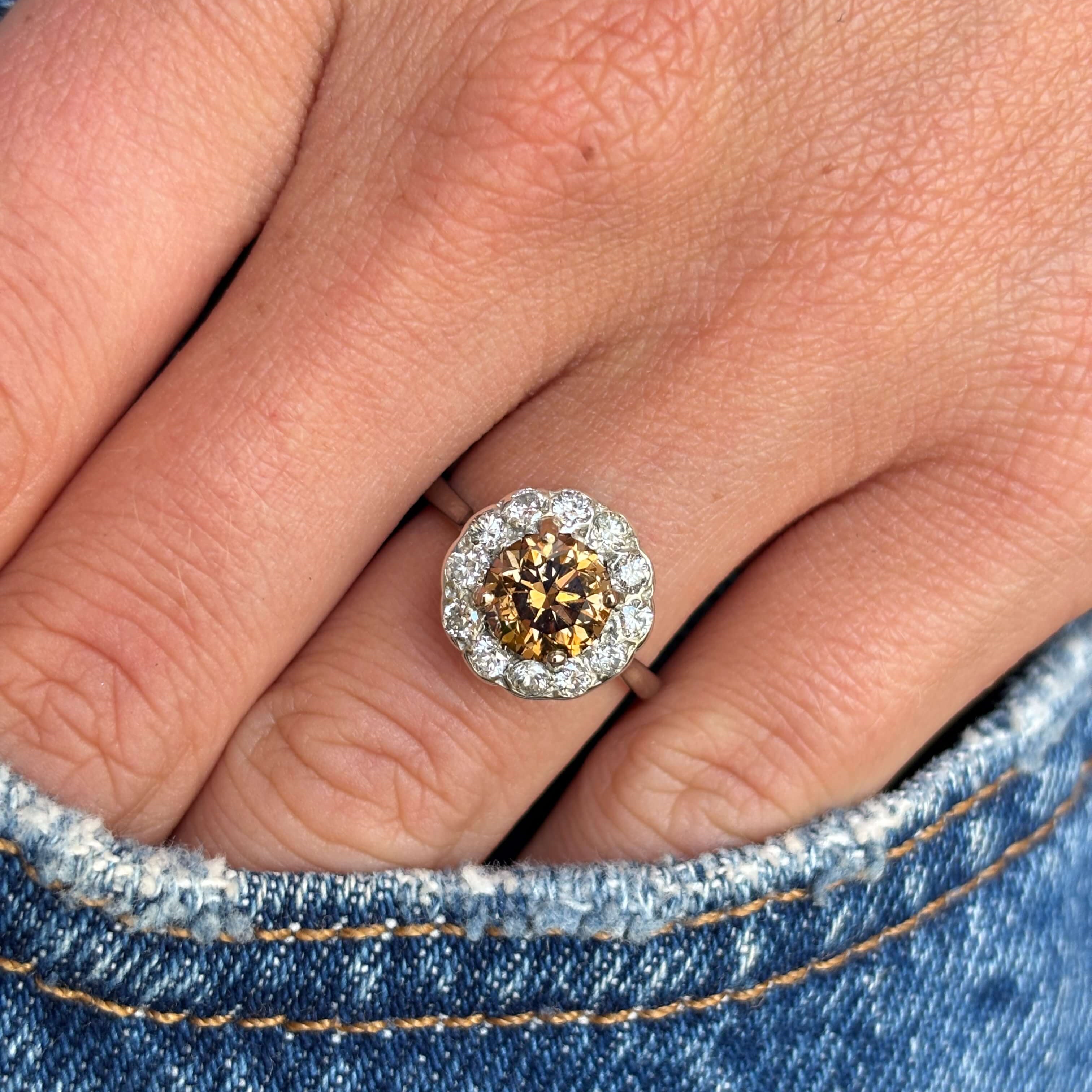Vintage 1950s cinnamon brown diamond cluster engagement ring with a cinnamon brown diamond centre stone and diamond halo, worn on a hand.