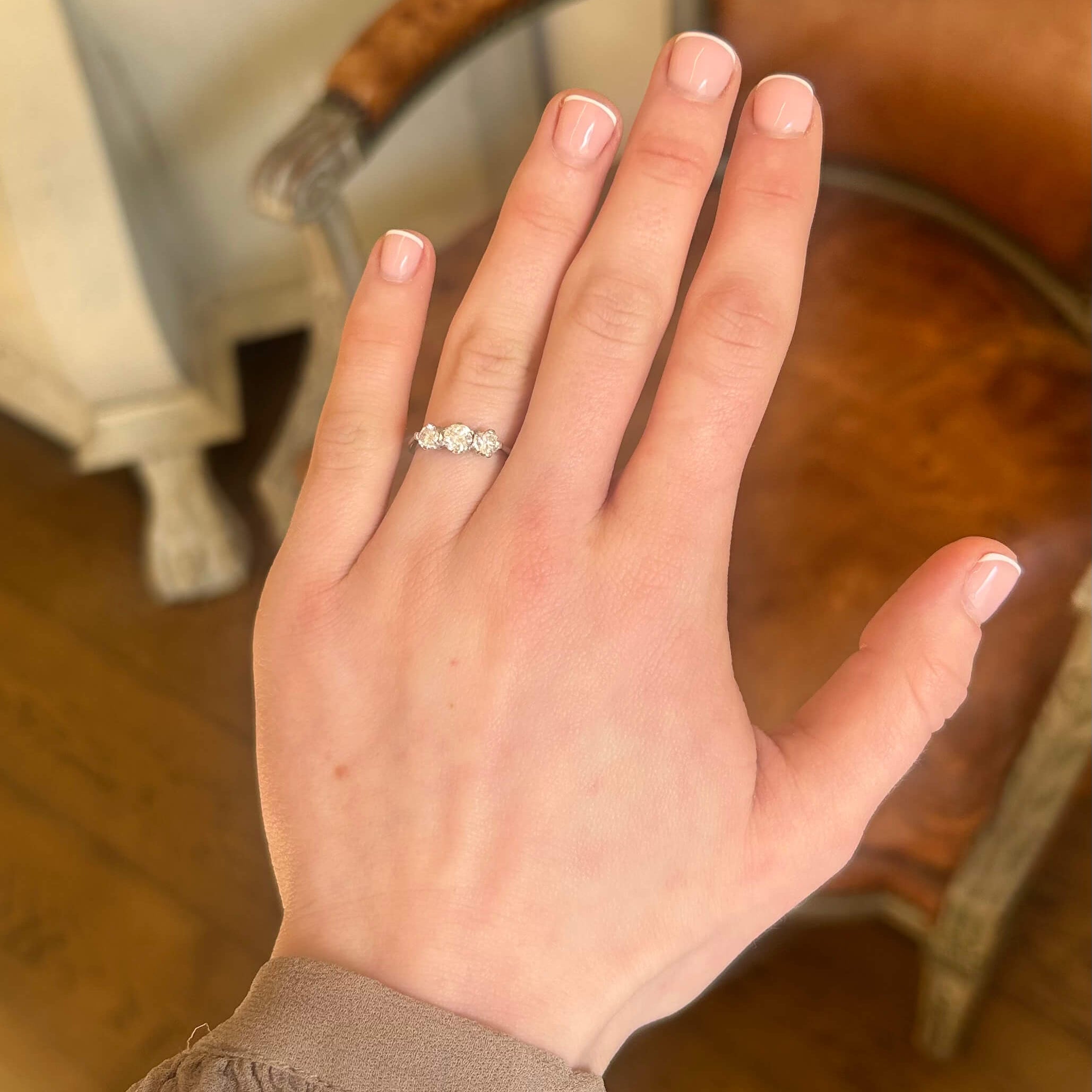 Vintage 1950s diamond three stone ring in white gold on hand.