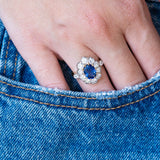 Vintage 1960s French sapphire and diamond cluster ring worn with hand resting in denim pocket.
