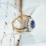 Vintage 1960s French sapphire and diamond cluster ring with raised diamond cluster setting and yellow gold band.