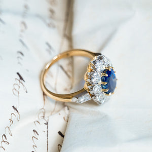Vintage 1960s French sapphire and diamond cluster ring with raised diamond cluster setting and yellow gold band.