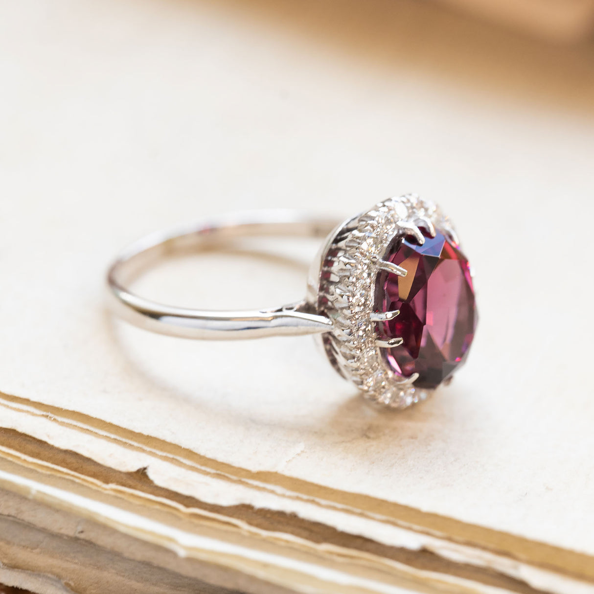 Vintage 1960s garnet and diamond cluster ring with oval garnet centre stone and diamond detailing.