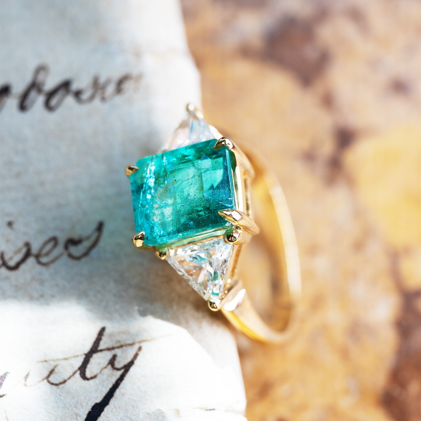 Vintage 1970s emerald and diamond three stone ring highlighting emerald cut centre and diamond side stones.