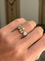 Vintage 1970s yellow sapphire and old-cut diamond three-stone engagement ring featuring a yellow sapphire centre stone and old-cut diamond accents, worn on a hand.
